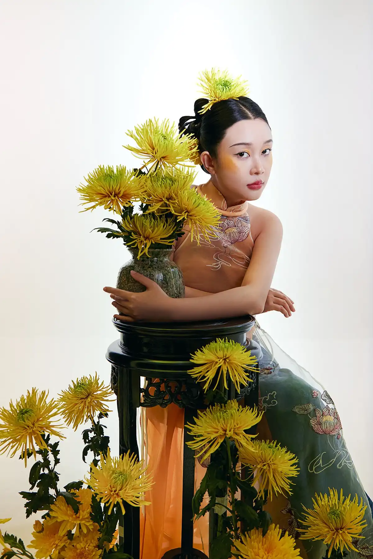 Bộ ảnh gây ấn tượng bởi sắc vàng chủ đạo, trải dài từ trang phục áo dài cách tân, bình hoa cúc rực rỡ, đến những mảng mây cách điệu. 2i2a0665.jpg