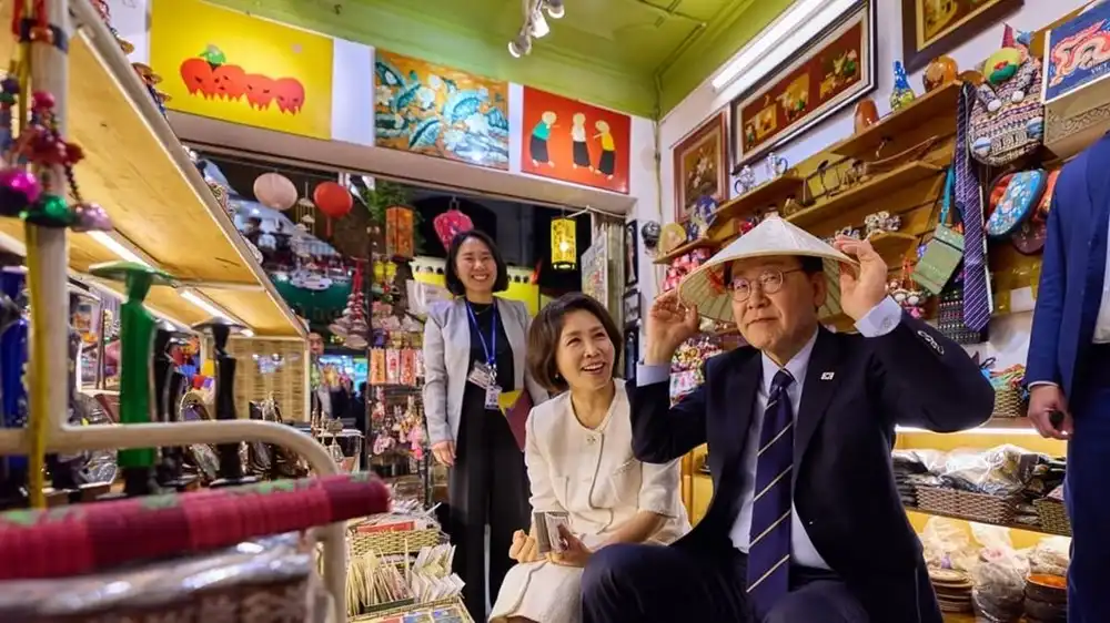 Hình ảnh Tổng thống Hàn Quốc và phu nhân mua đồ lưu niệm tại một cửa hàng trong phố cổ Hà Nội